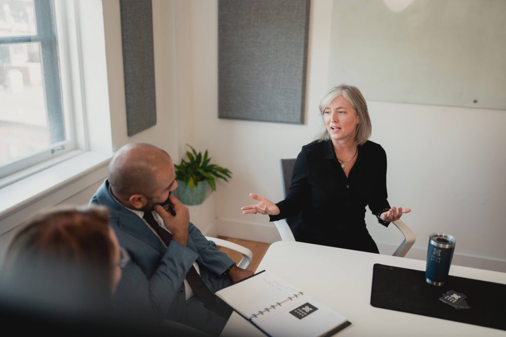 Four Eyes team members collaborating around a meeting table in the office