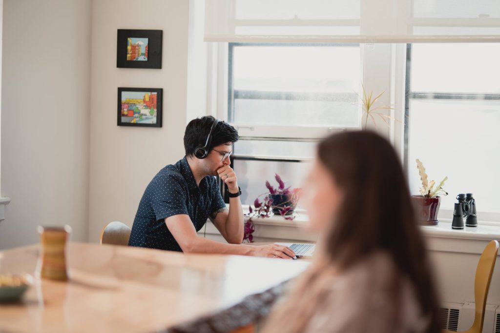 Four Eyes team member on a call at a shared table by the office windows