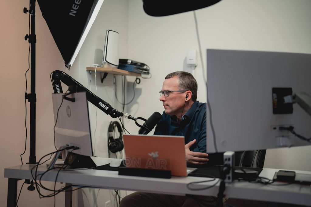 Four Eyes team member recording a podcast in the office studio