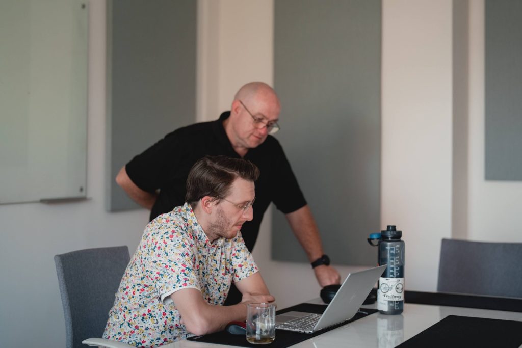 Two Four Eyes colleagues reviewing work together on a laptop