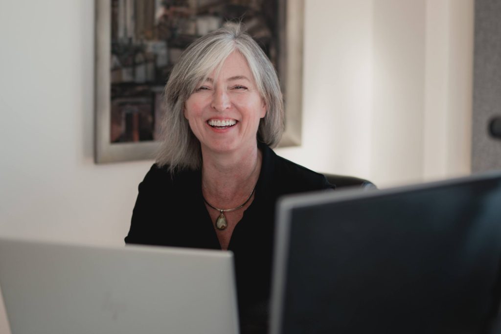Four Eyes team member smiling at her desk in the office