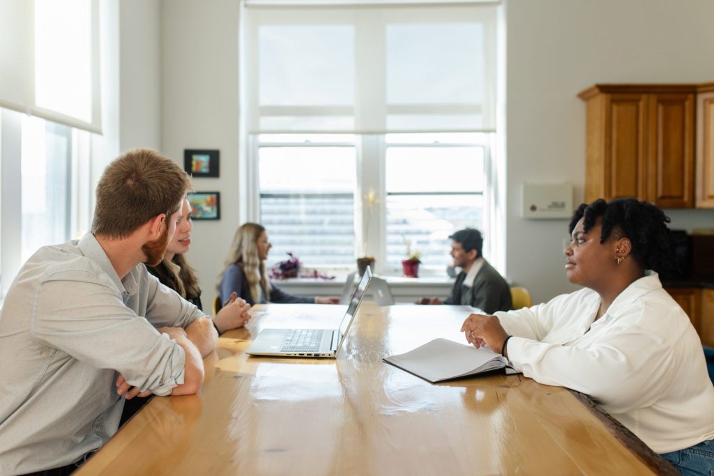 Four Eyes team meeting around a long table in the office