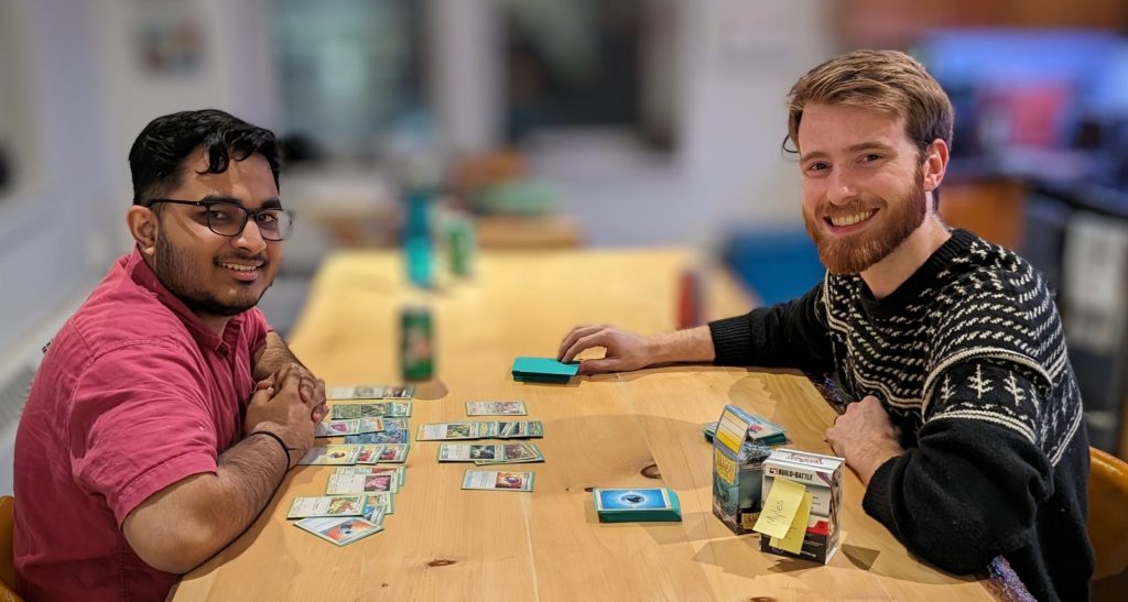 Two Four Eyes colleagues playing a card game at the office table