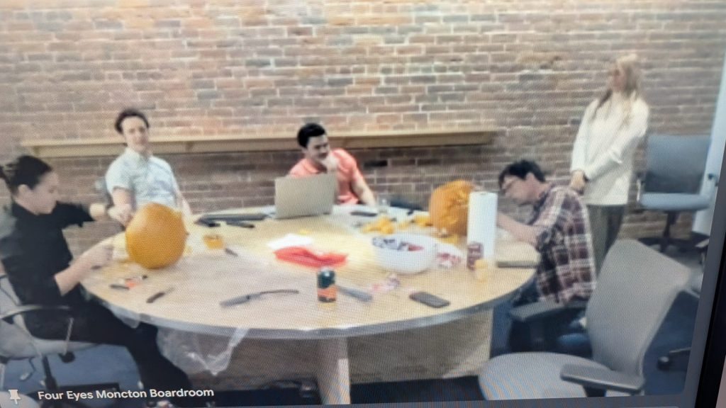 Four Eyes team carving pumpkins in the boardroom