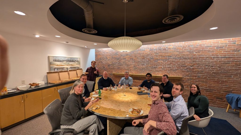 Four Eyes team sharing a meal around the boardroom table