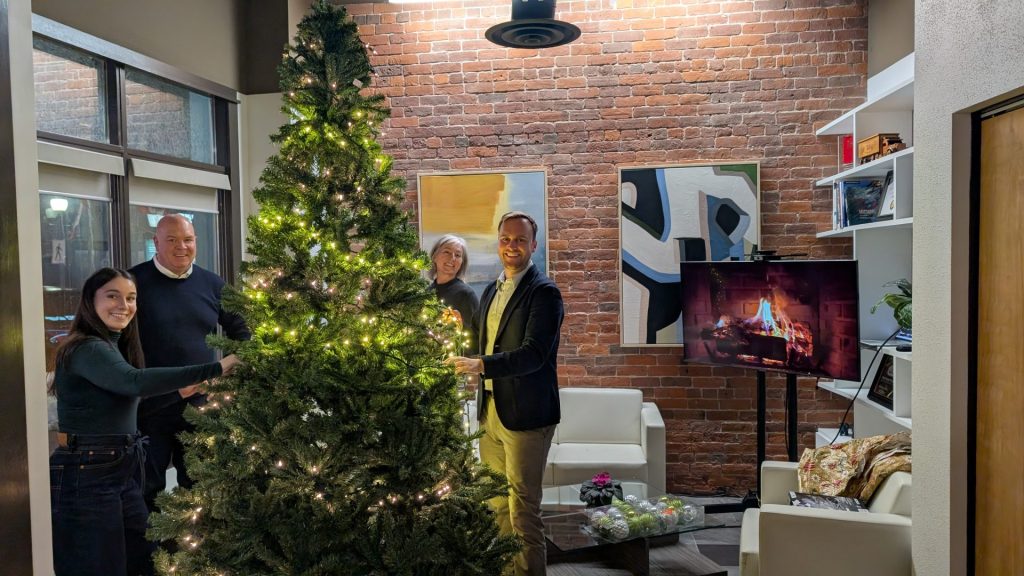 Four Eyes team members decorating the office Christmas tree