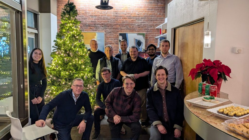 Four Eyes team group photo beside the office Christmas tree